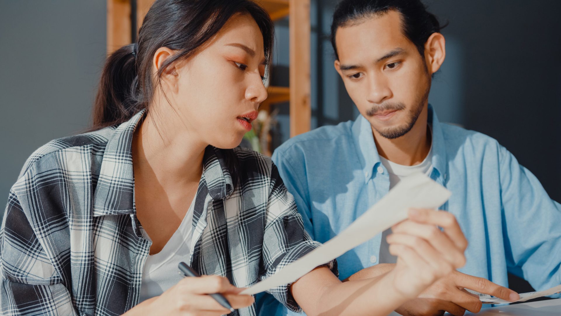 Stress asia couple man and woman use calculator for calculate family budget, debts, monthly expenses during financial economic crisis at home. marriage money trouble, Family budget planning concept.